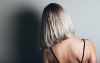 Model with unrecognizable face with blond shiny hair. Woman bob haircut styling. Back view
